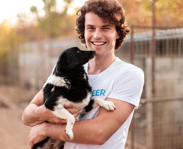 Volunteer holding dog at shelter.