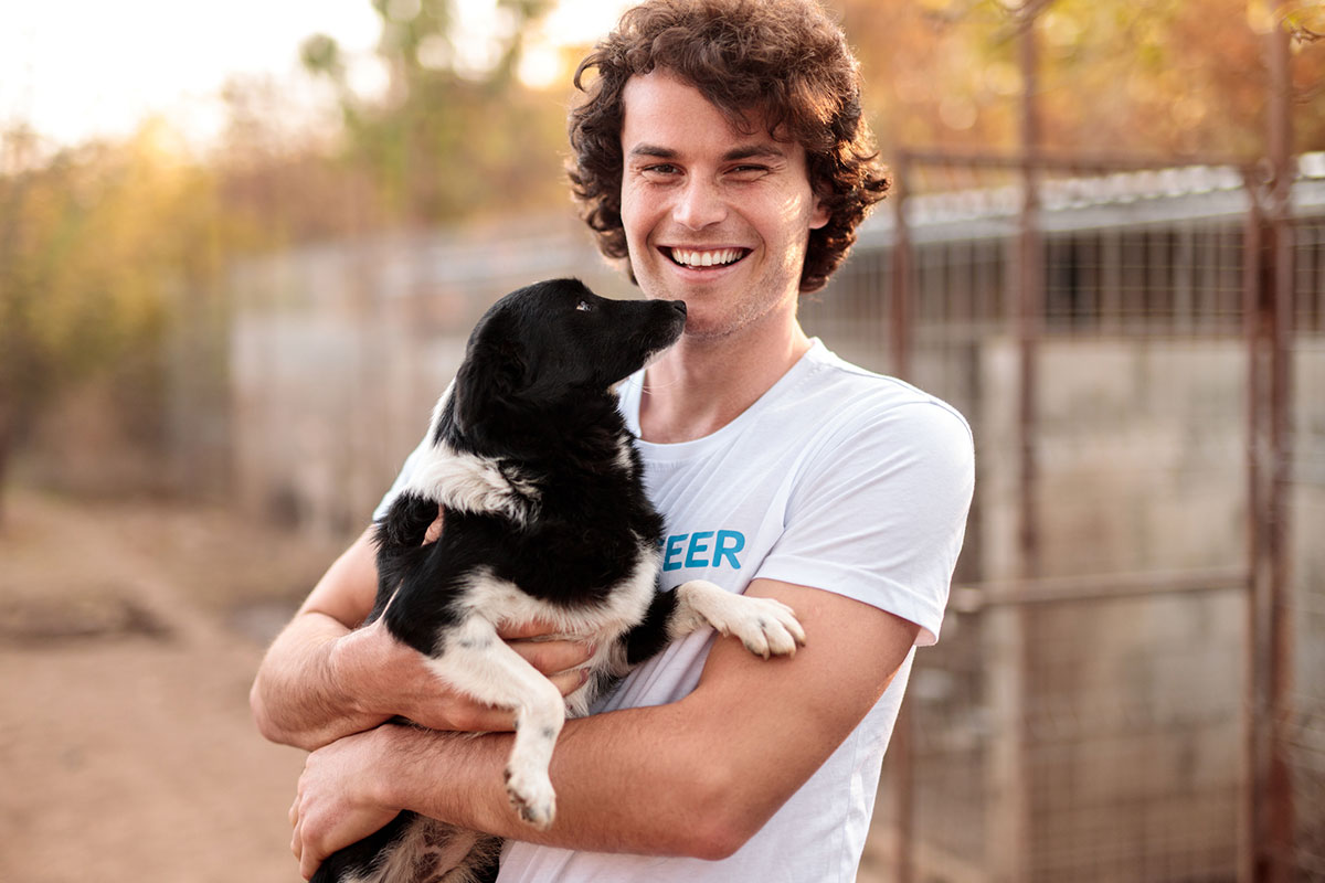 Volunteer holding dog at shelter.