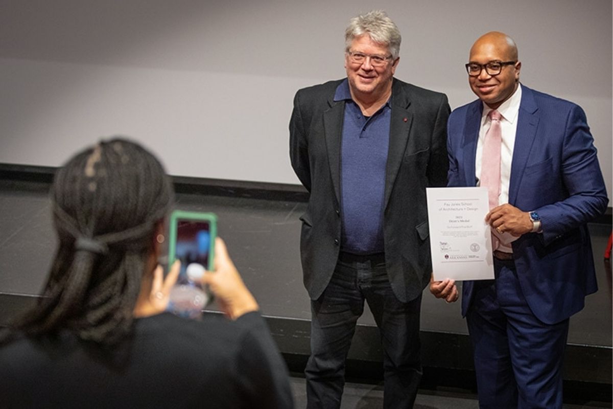 Dean Peter MacKeith, at left, and Ryan Watley get their photo taken during an awards ceremony held on Dec. 9 in Vol Walker Hall. Watley is CEO of Go Forward Pine Bluff, which was a 2021 Dean's Medal recipient.