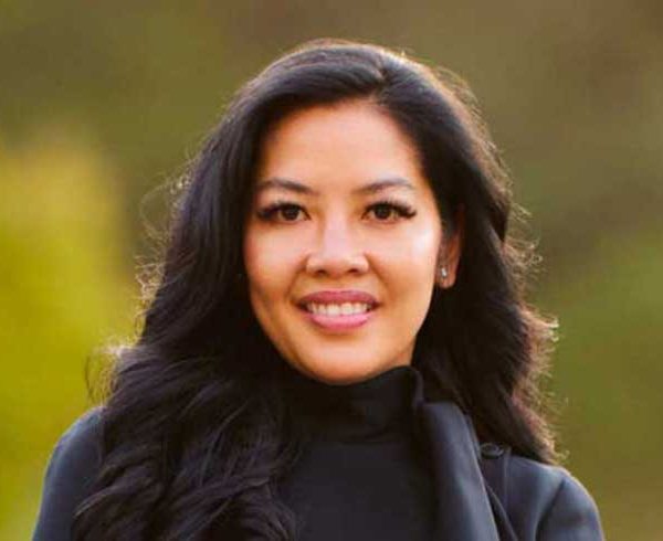 Philana Bouvier posing in dark suit in a vineyard.