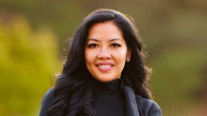 Philana Bouvier posing in dark suit in a vineyard.