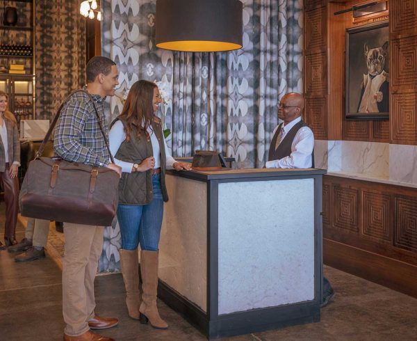 A stylish couple checking in at The Louis Hotel in Wilson, Arkansas.