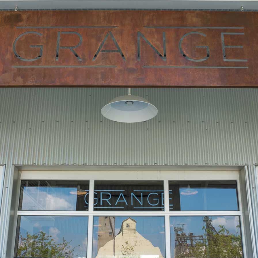 Entrance of The Grange with metal sign hanging above doorway.